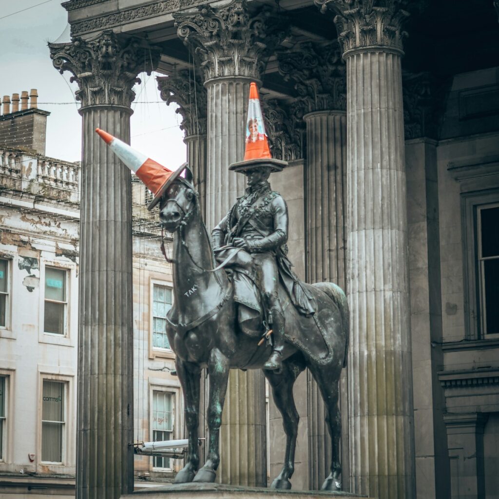 statue of man riding horse near white concrete building during daytime